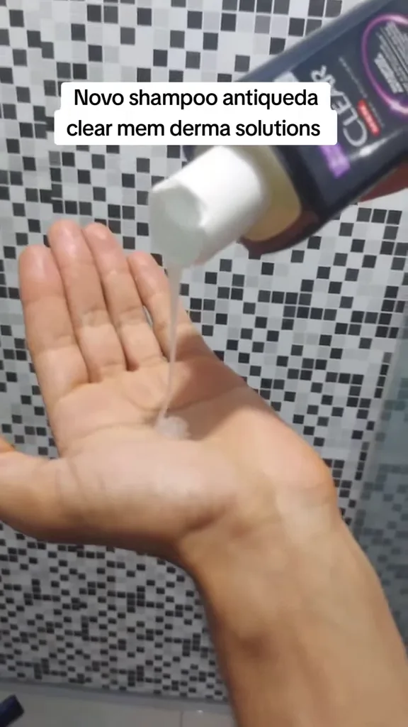 Frasco despejando o shampoo Clear Men antiqueda na palma da mão