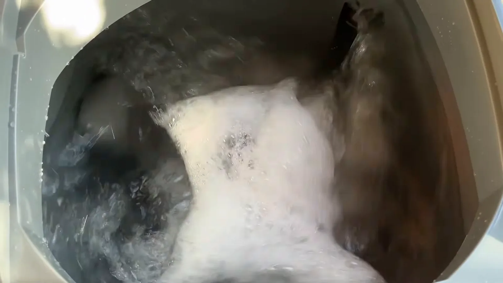 Tanquinho Colormaq lavando roupas com água e bastante espuma