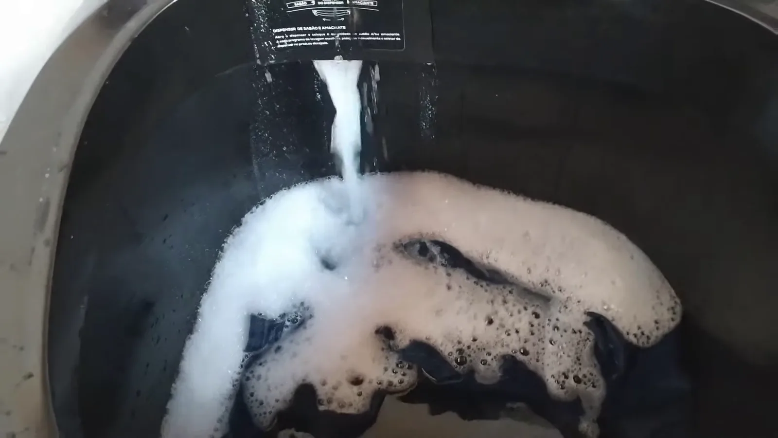 Dispenser despejando água com sabão dissolvido diretamente na cuba