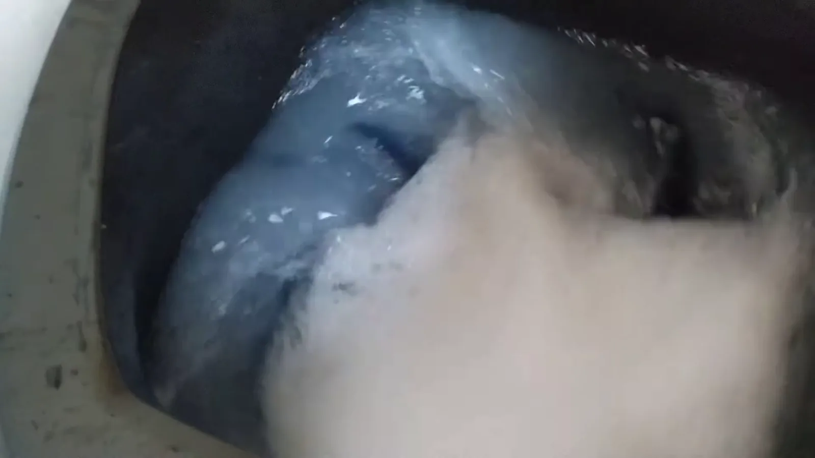 Tanquinho agitando a carga pesada de roupas com espuma abundante