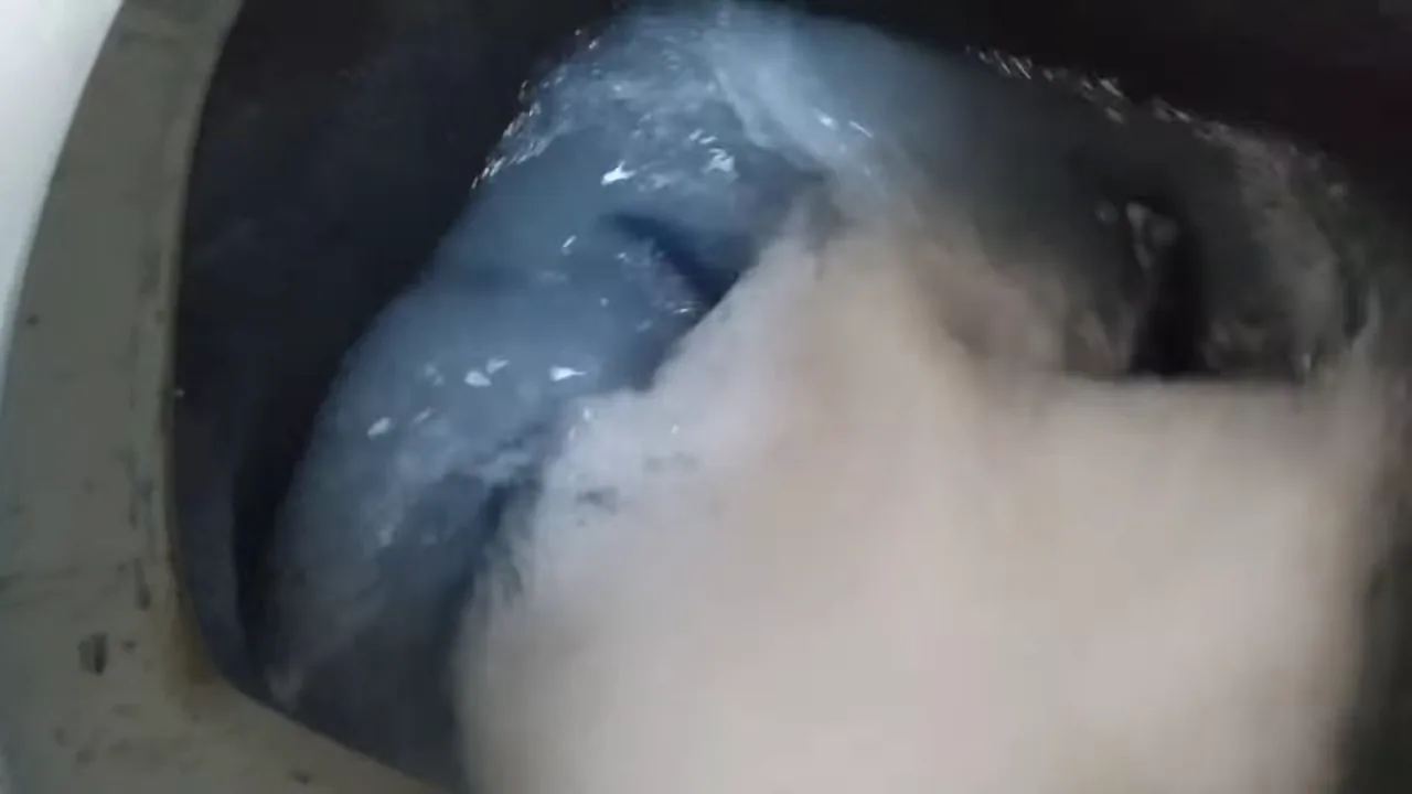 Tanquinho em funcionamento agitando grande quantidade de roupas com espuma