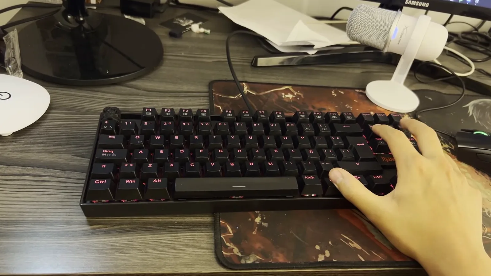 Mão apoiada sobre o teclado mecânico Redragon Kumara iluminado