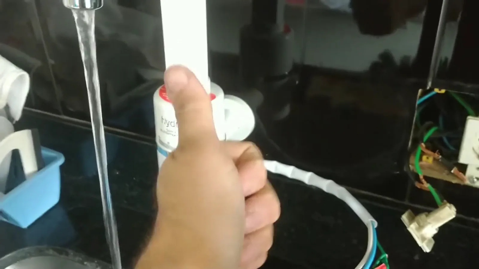 Torneira elétrica Hydra Slim aberta com fluxo de água na pia