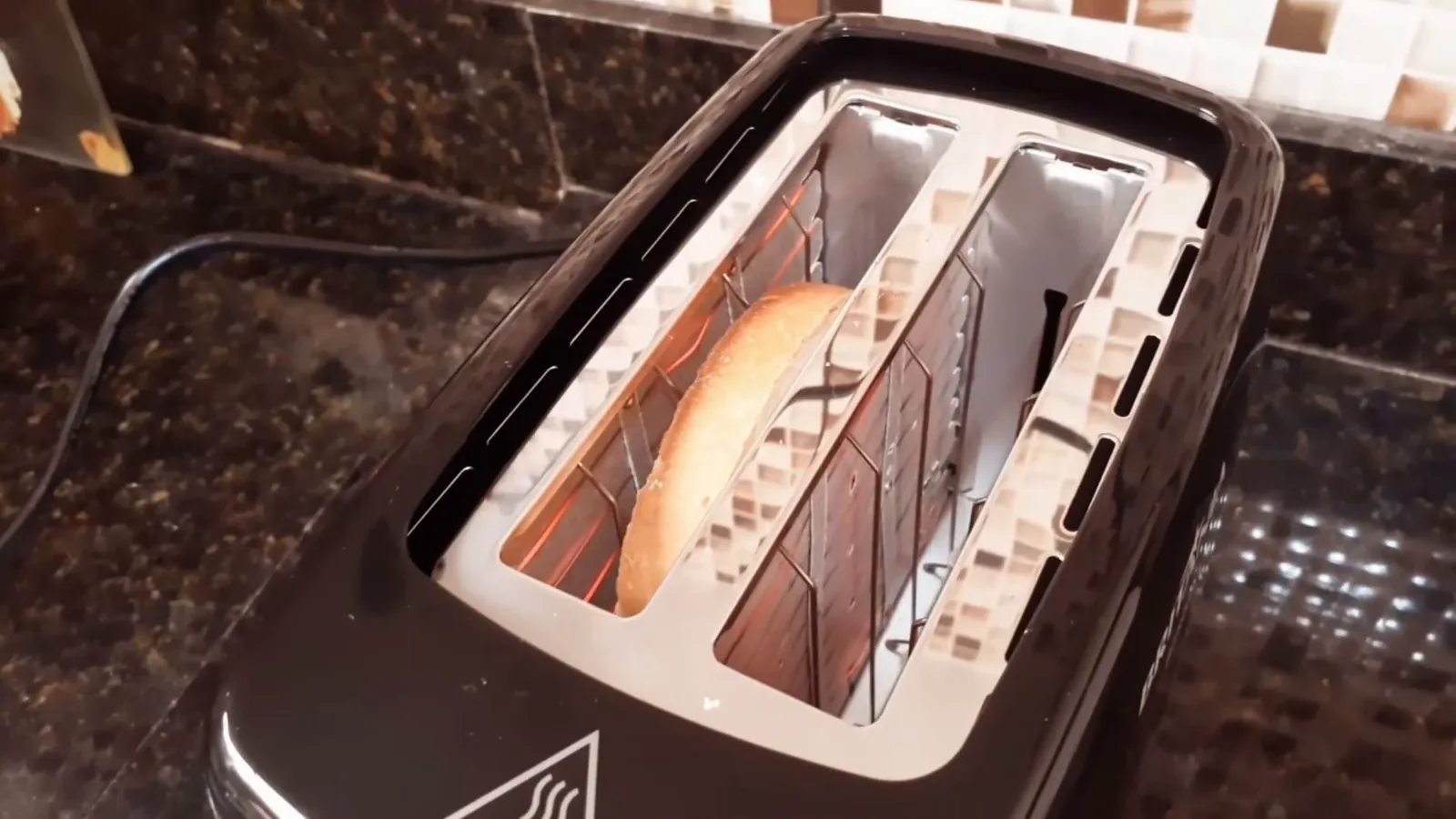Torradeira elétrica em funcionamento com fatia de pão sendo tostada