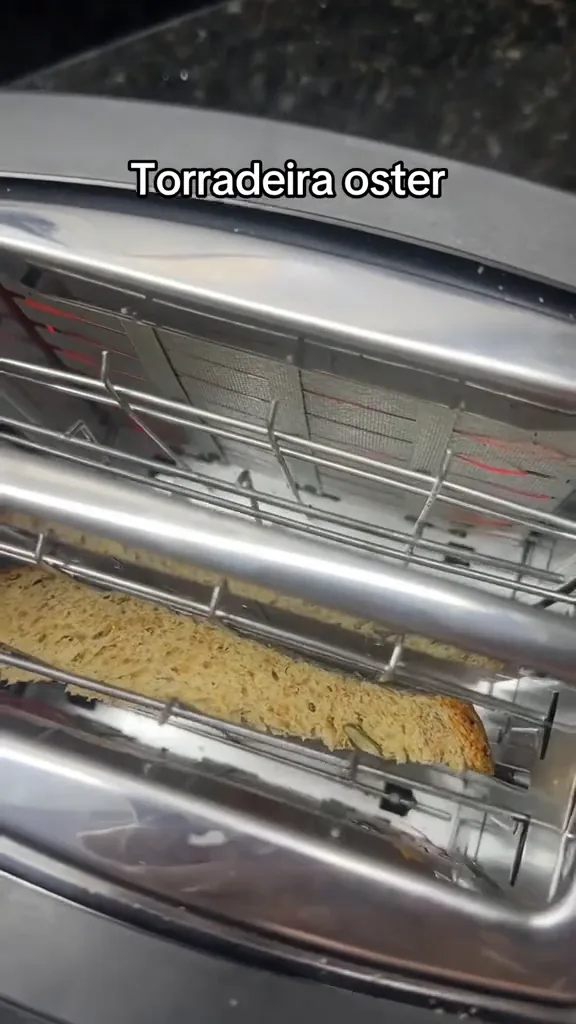 Resistências elétricas aquecidas tostando o pão na torradeira Oster