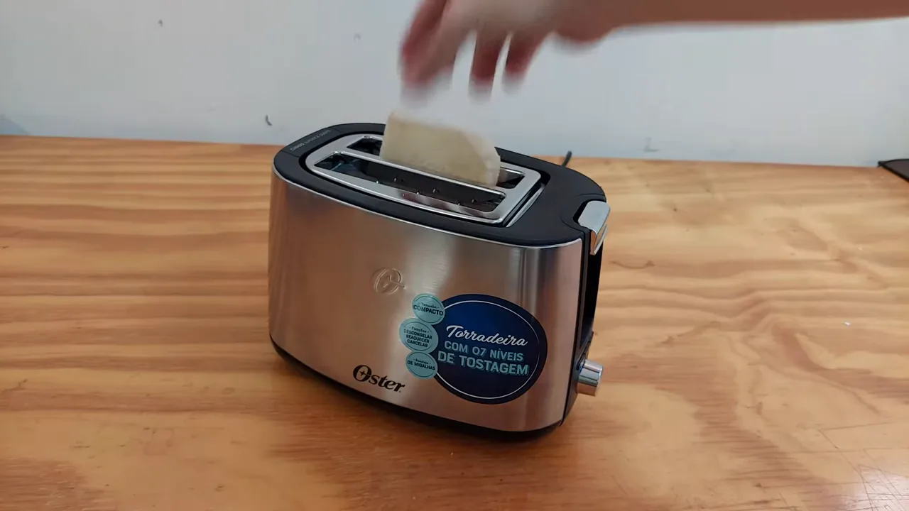 Inserção de fatias de pão nas aberturas da torradeira Oster