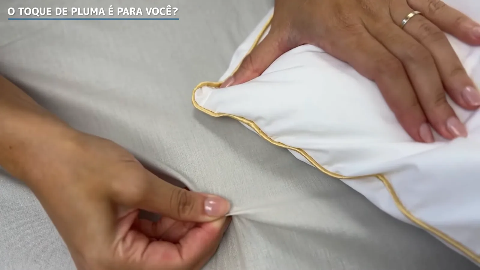 Detalhe das mãos sentindo a capa de algodão do travesseiro