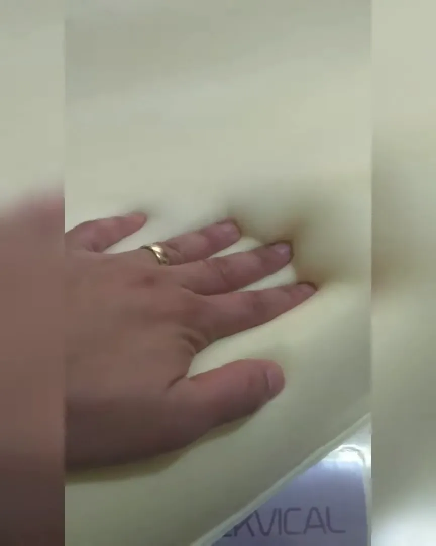 Espuma viscoelástica do travesseiro sendo pressionada para demonstrar maciez