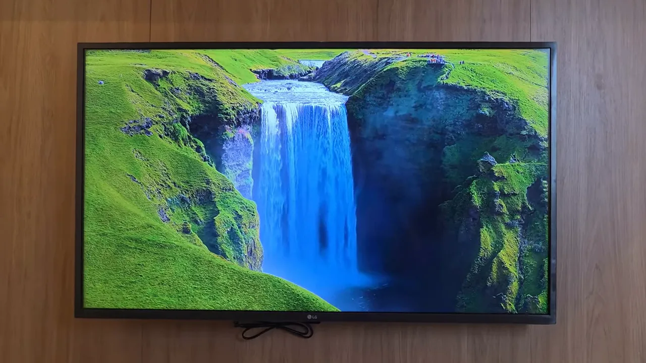 Smart TV exibindo vídeo de paisagem natural com cachoeira em movimento