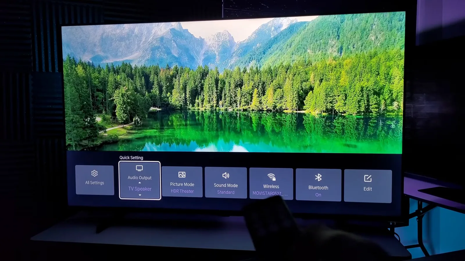 Smart TV reproduzindo paisagem natural com menu de ajustes na tela