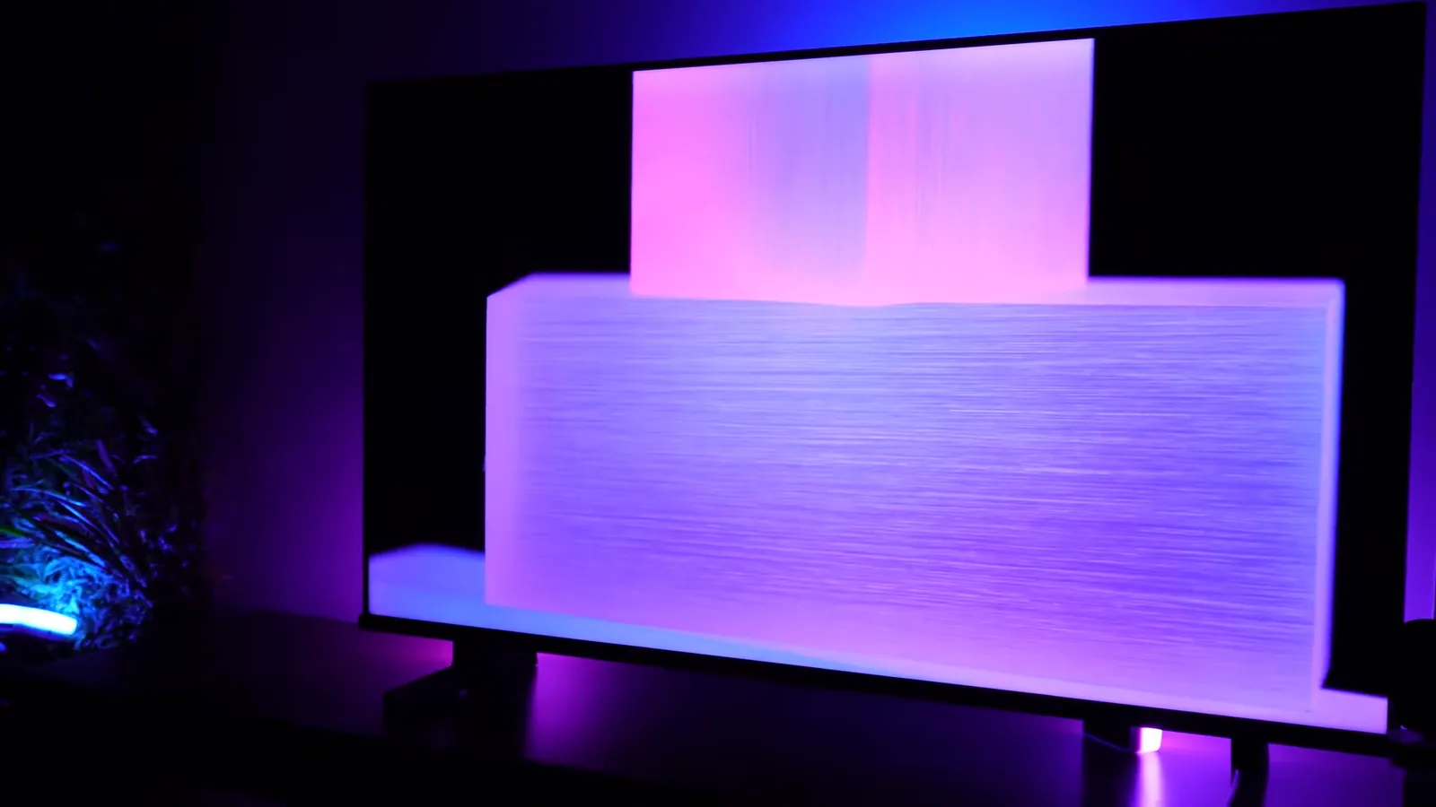 Painel da TV exibindo formas geométricas com iluminação uniforme em ambiente escuro