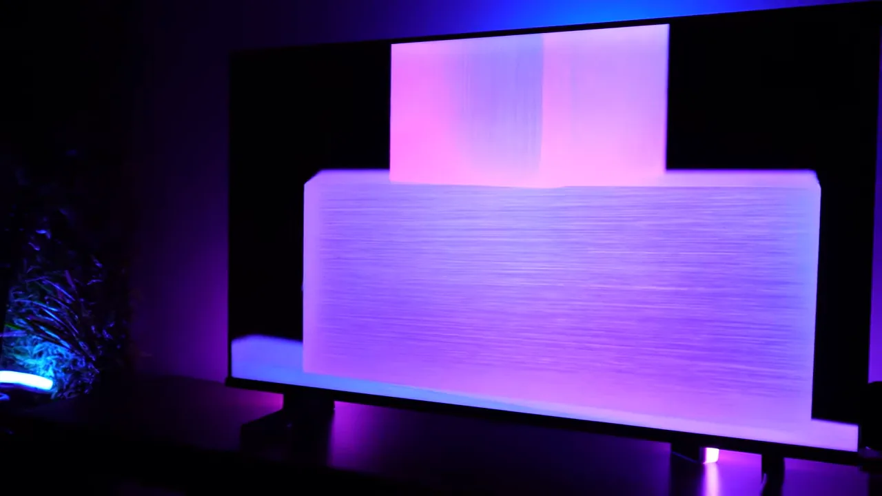 TV exibindo animação com formas geométricas iluminadas em sala escura