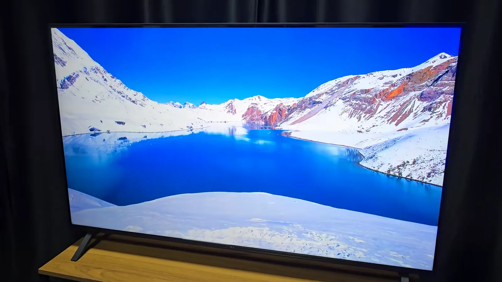 Smart TV LG UA85 exibindo paisagem de montanhas nevadas e lago
