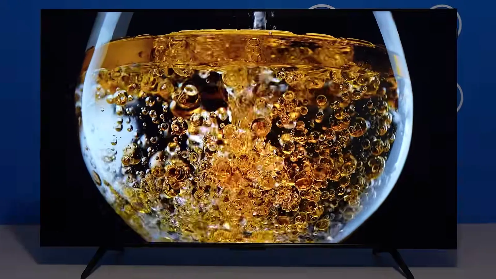 Tela da smart TV exibindo líquido dourado com alto contraste