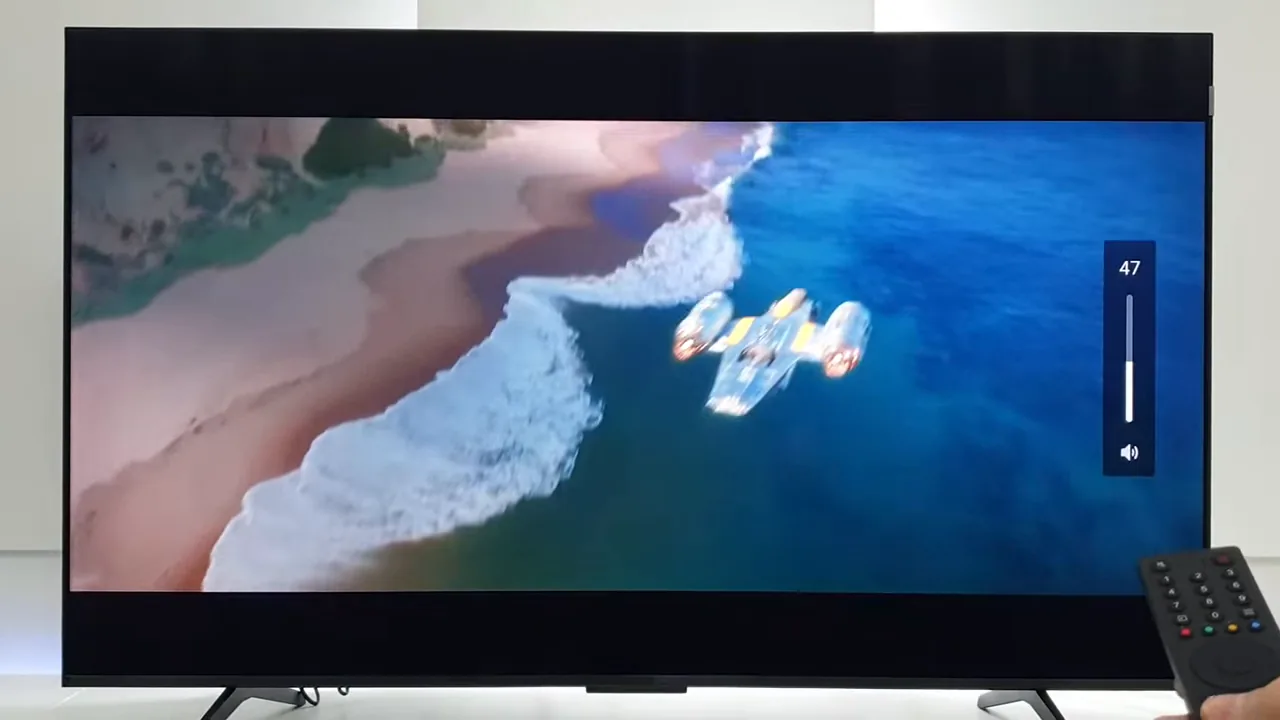 Smart TV reproduzindo vídeo litorâneo em alta definição e regulando volume