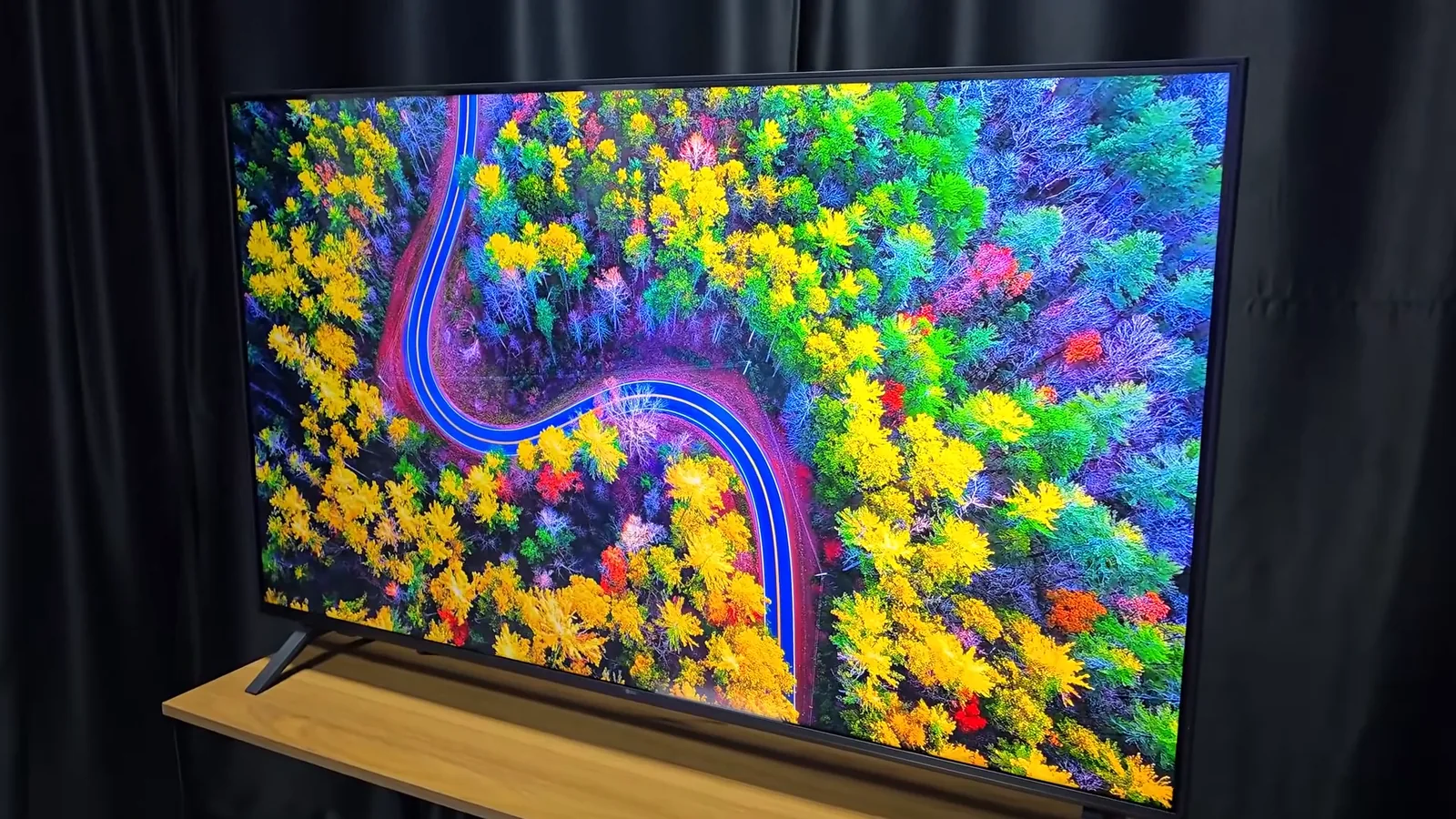 Smart TV reproduzindo paisagem de floresta colorida com estrada sinuosa