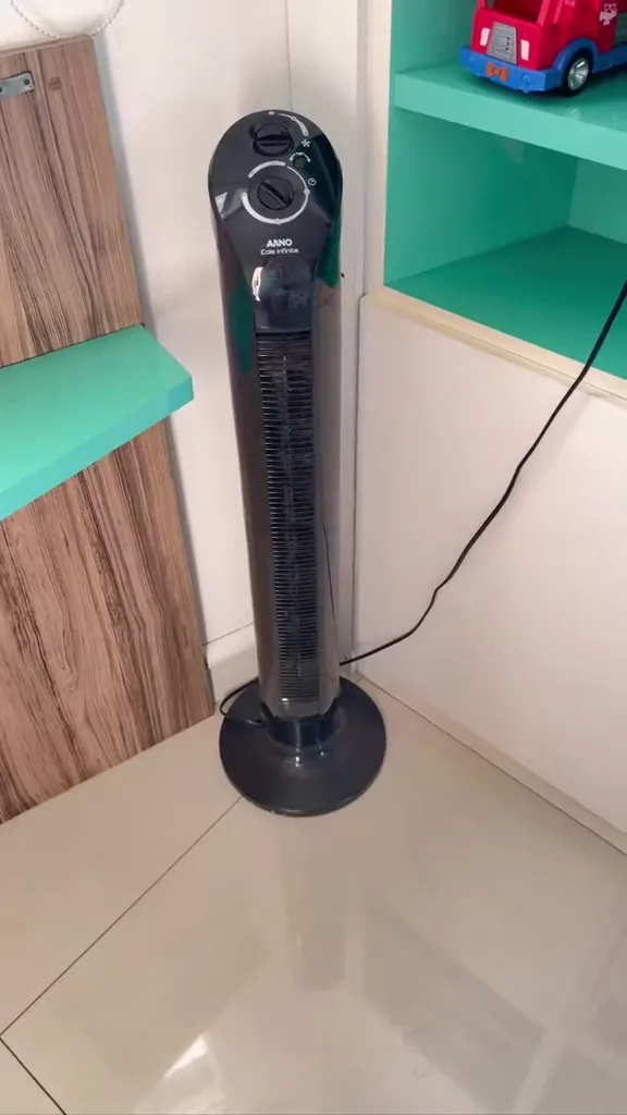 Ventilador de torre Arno oscilando em funcionamento no canto da sala