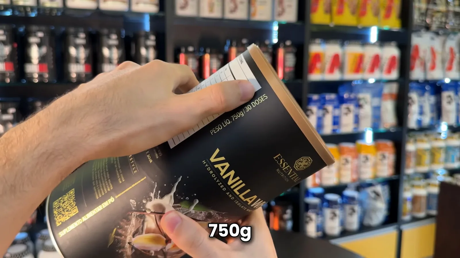 Lata de Vanilla Whey Essential Nutrition segurada pelas mãos