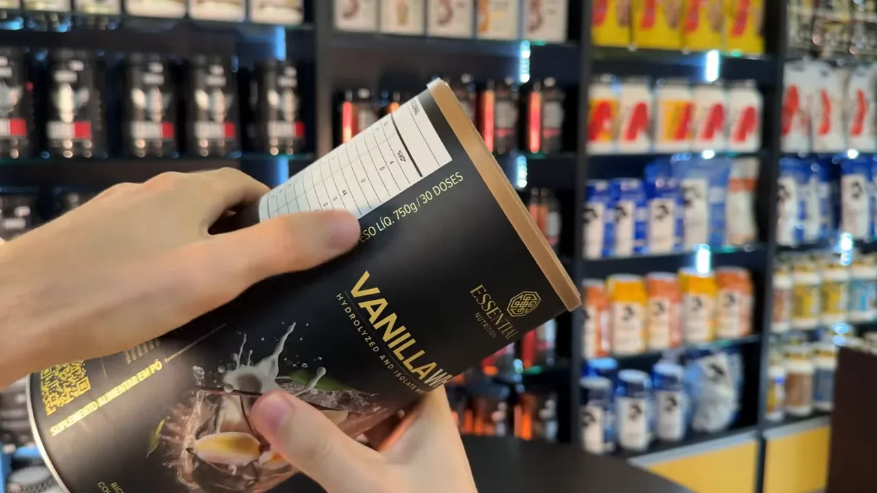 Manuseio da lata destacando a embalagem frontal de Vanilla Whey