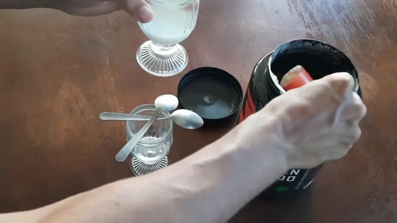 Despejando o pó de whey concentrado no copo para o preparo
