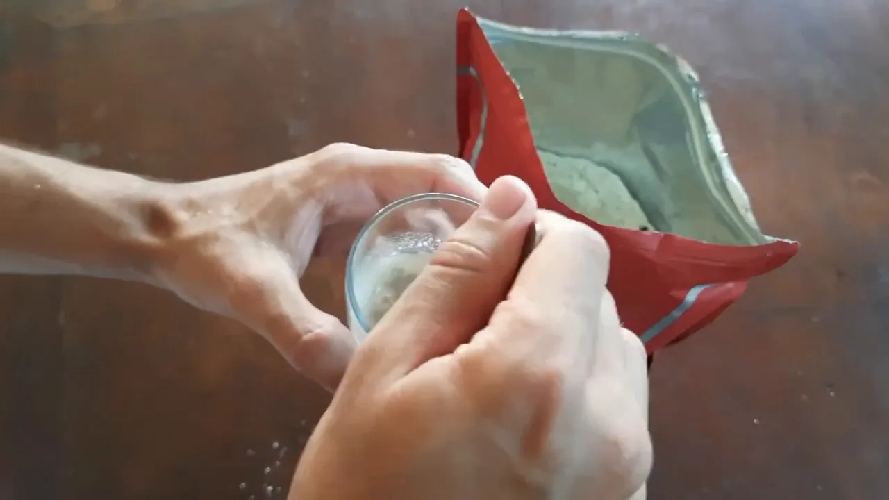 Diluição do whey concentrado em copo de água na mesa