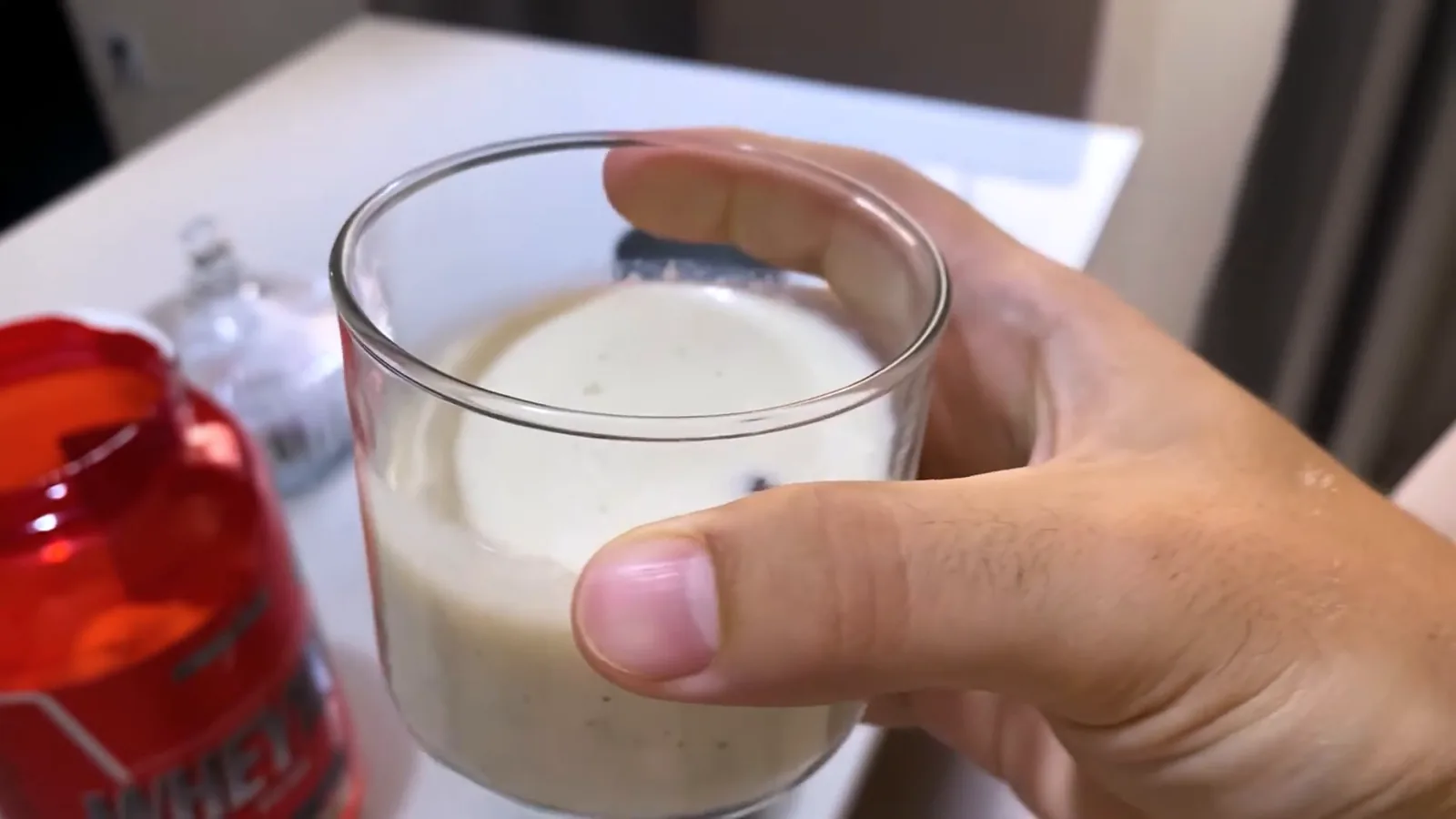 Copo com shake preparado de whey protein Integralmédica na mão