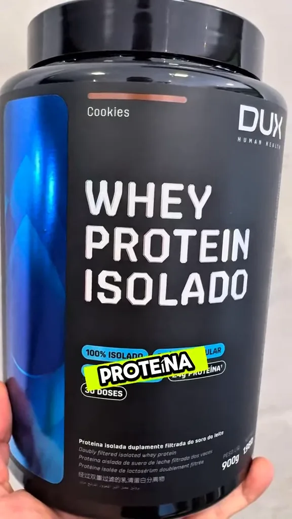 Embalagem do whey protein isolado Dux sendo manuseada na mão